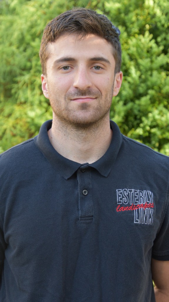 Portrait of Jake DiCesare, Manager, wearing an Esterly Link polo outdoors against soft-focus greenery.